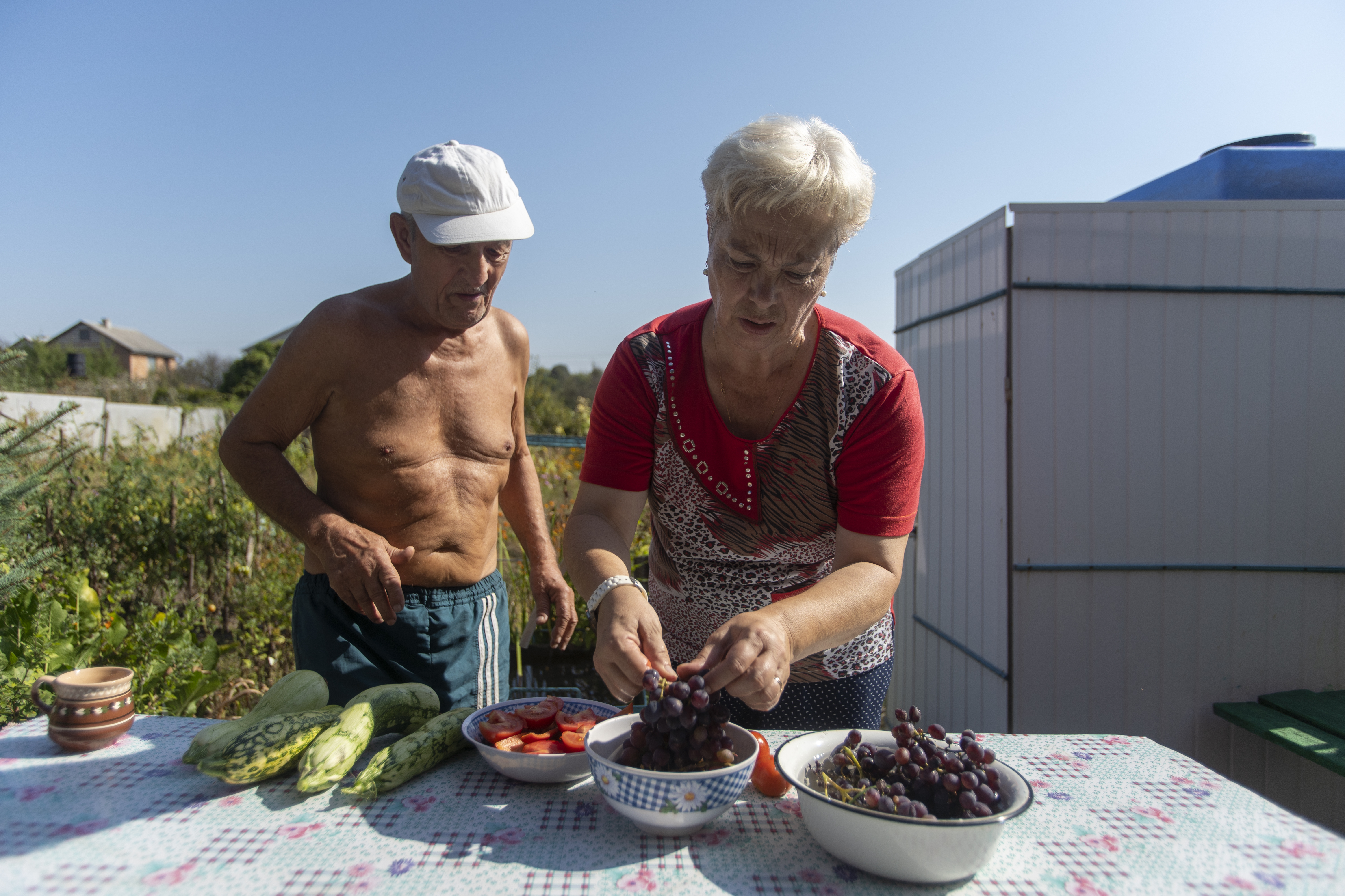 Viktor and Lubov prepare fresh cucumber, tomato, and grapes at their dacha (AtlasNetwork.org Photo/Bernat Parera).