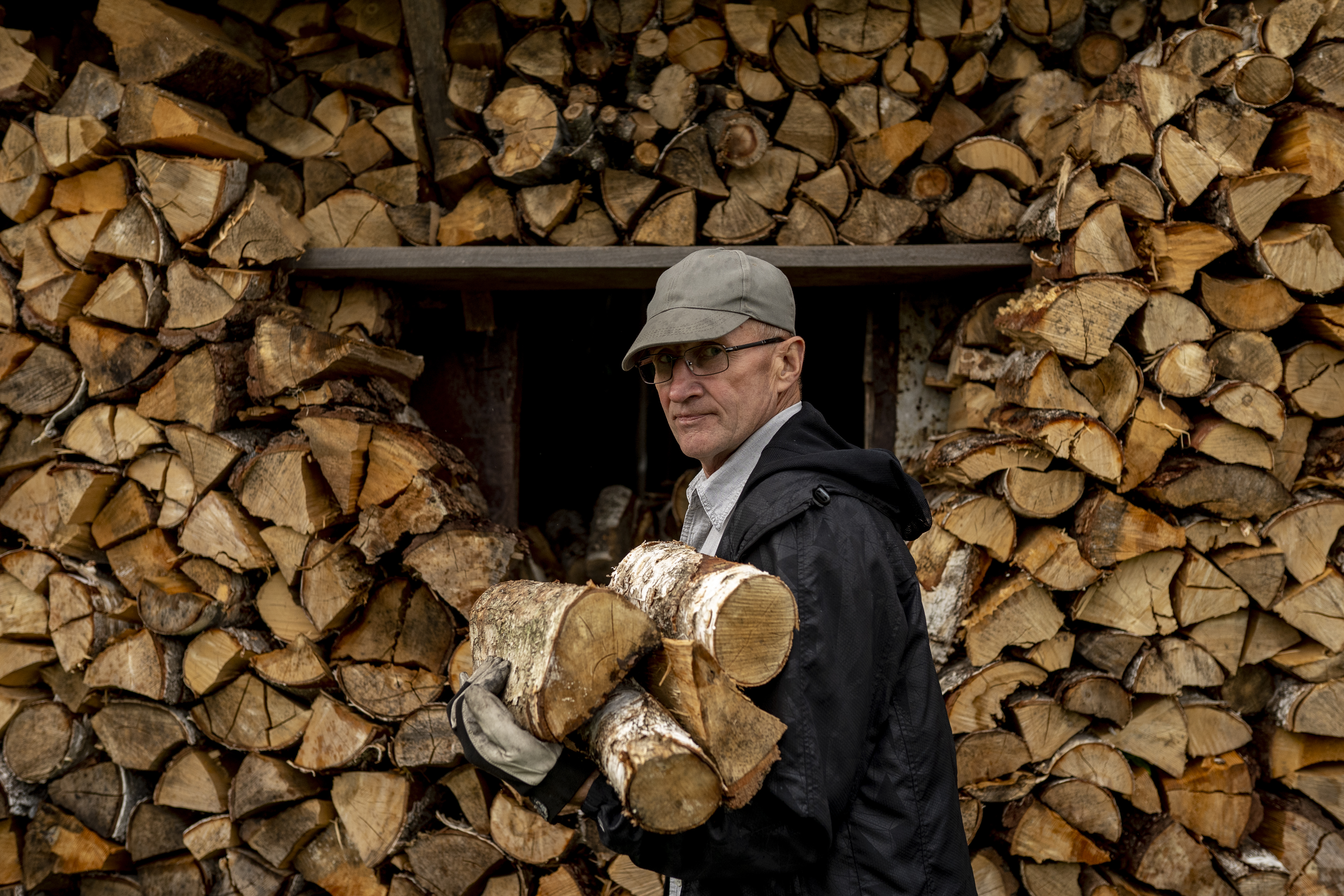 Ona’s husband gathers birch wood for the fire that will bake the šakotis (AtlasNetwork.org Photo/Bernat Parera).