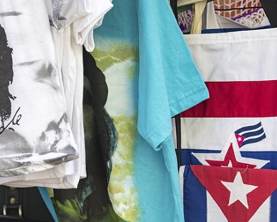 Trinidad, Cuba — February 5, 2016 — Local business kiosk selling Cuban souvenirs like Che Guevara t-shirts, and shopping bags with Cuban flags on the side. Photo: DayOwl / Shutterstock.com