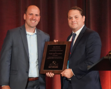 Steven Anderson, president and chief executive officer of Pacific Legal Foundation, accepts the 2019 North America Liberty Award from Atlas Network President Matt Warner.