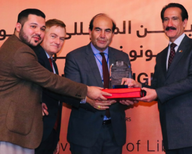 Dr. Tom G. Palmer joins Afghan colleagues in presenting an award for promotion of human rights at the AELSO conference.